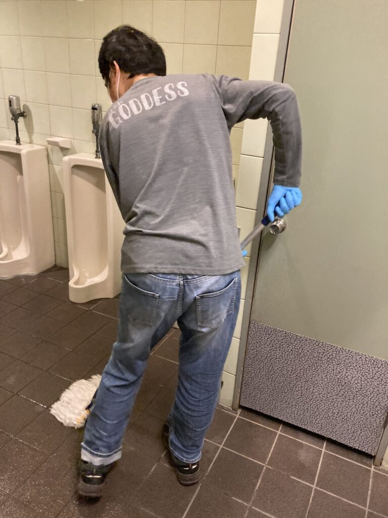 手順を守り丁寧にトイレ清掃を行う様子。報告連絡相談の実践の場。