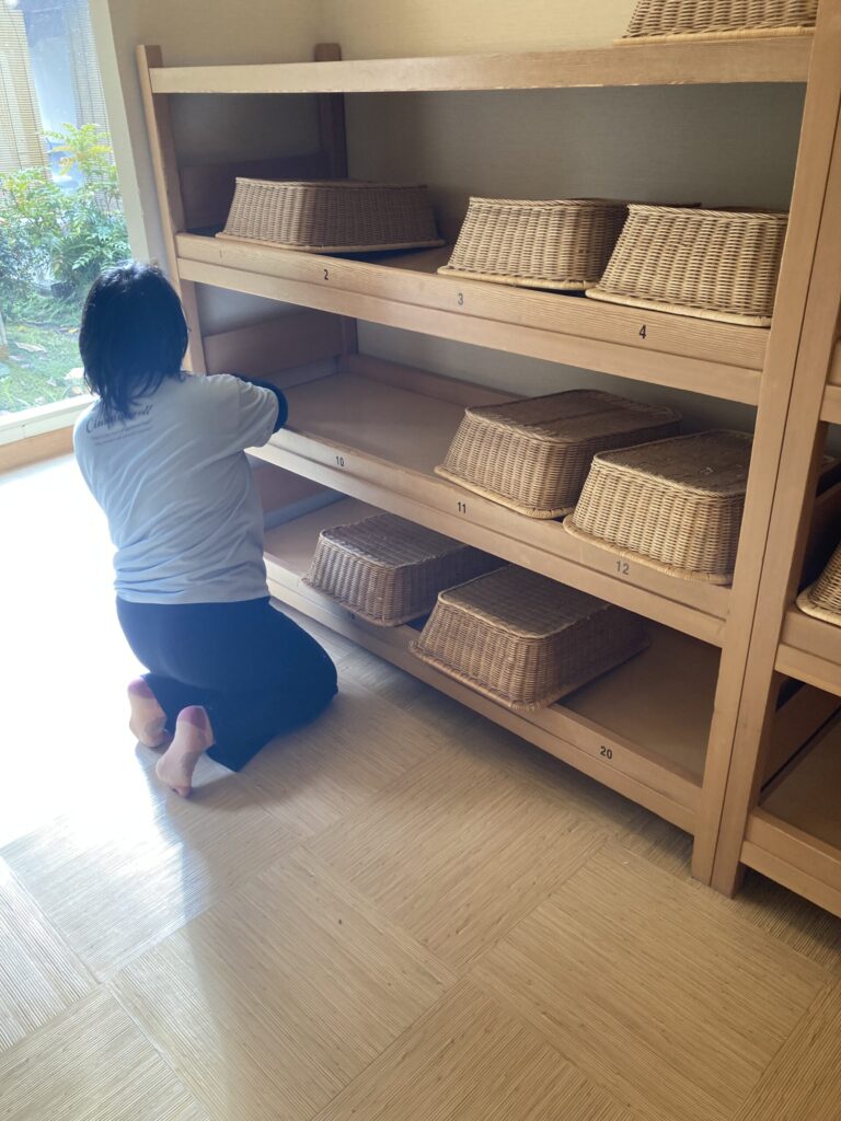 脱衣所のカゴの向きを一つひとつ丁寧に揃える作業風景