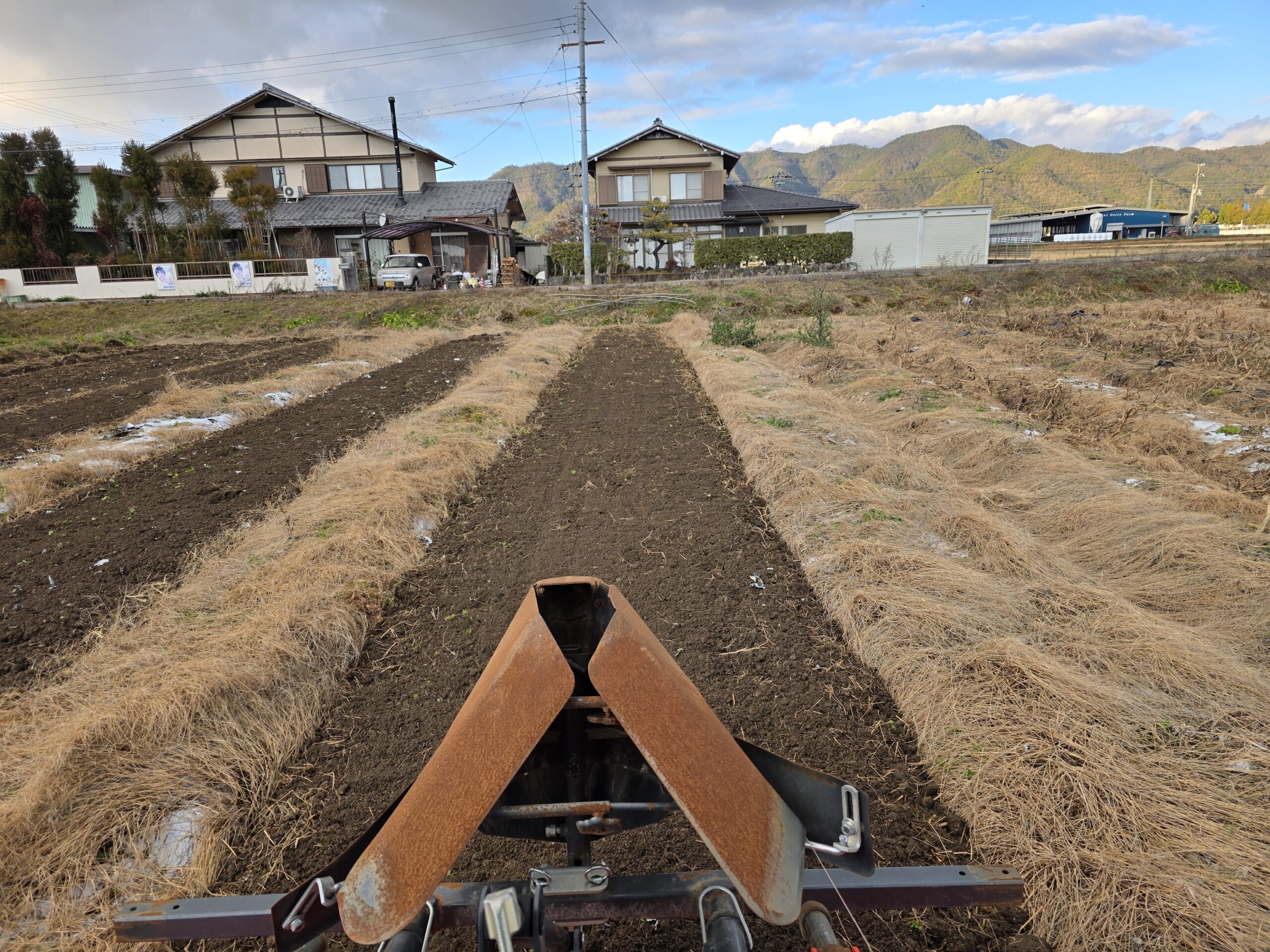 トラクターの操縦席から見た耕された畑と畝（うね）の様子