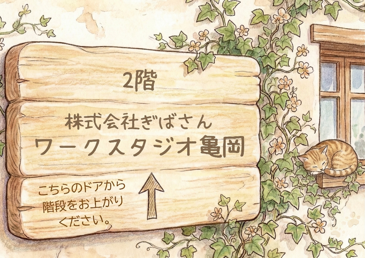 2階への案内が書かれたワークスタジオ亀岡のエントランス看板